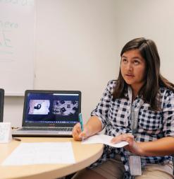 A student looking up to think, while studying.